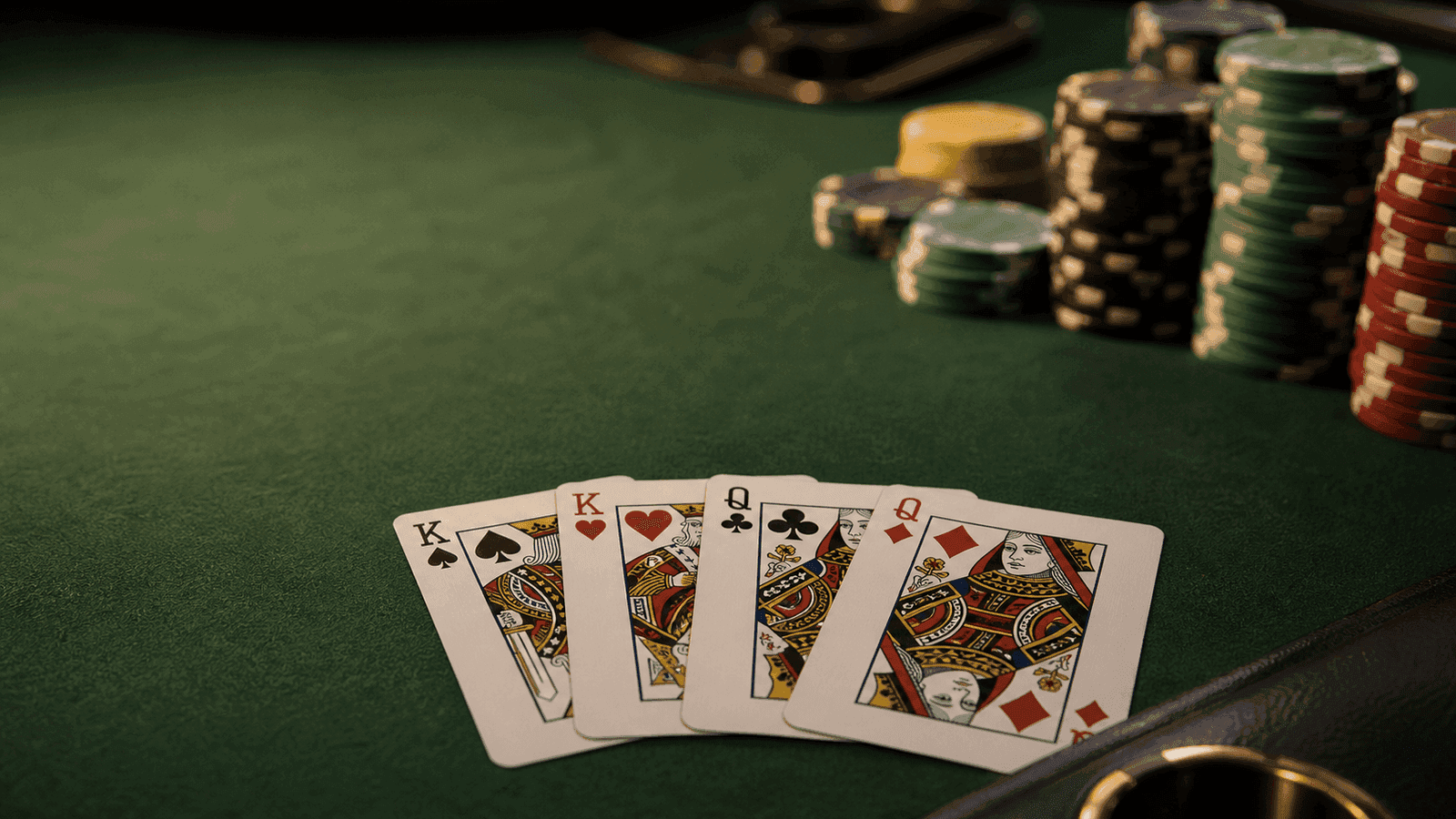 Two paired ranks show in a fanned Omaha hand beside chips on dark green felt.